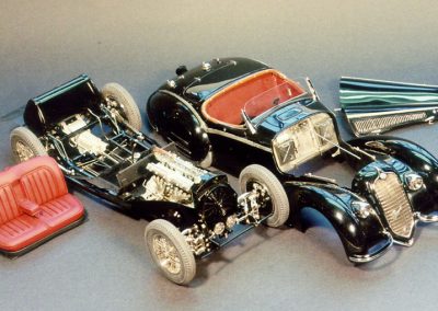 Here the black 1938 Alfa Romeo is pictured with the bodywork removed.