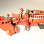 John's first engine model is flanked by scale firefighters.
