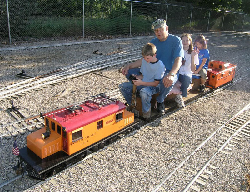 Richard With Family on a Loco Richard taking his nieces and nephew for a ride on his model locomotive.