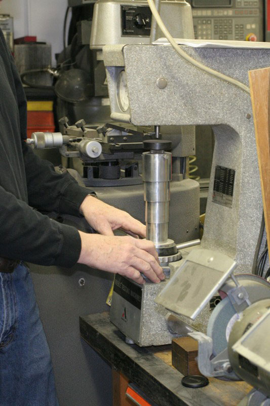 Conley67 Gary using the Rockwell Hardness Tester.