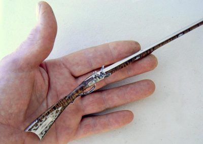 Rifle with hand for scale reference.