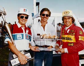 Mike With His Gold Car and Its Winners. Mike with one of his gold cars, and the racer who won it.