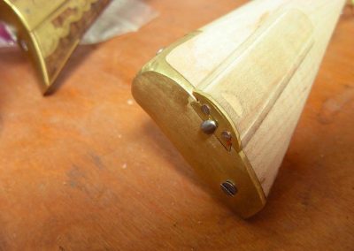 A brass butt plate installed on an unfinished stock.