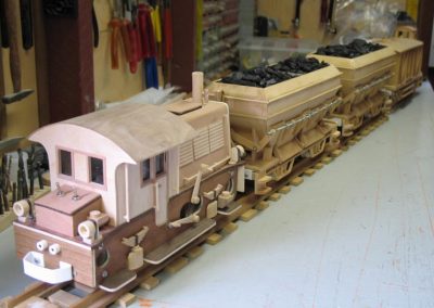A small yard switcher pulls a load of coal.