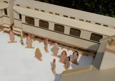 Wooden figures line the tracks.