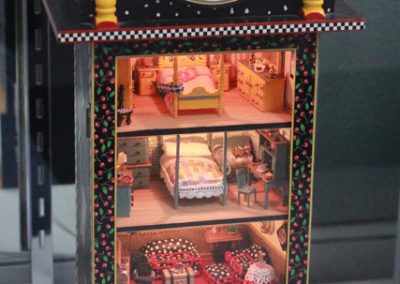 A dollhouse built into an old clock.