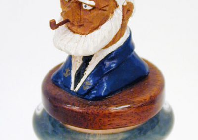 The hand-carved cork at the top of the ship in a bottle.