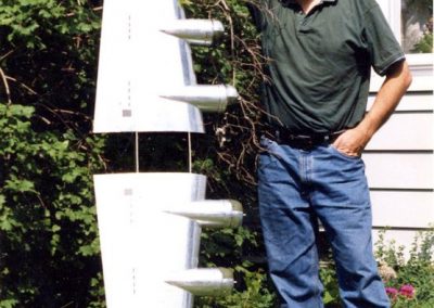 Guillermo standing with the finished pair of aluminum wings.