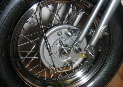 A close-up of the front wheel shows the drum brake, with brake cable affixed.