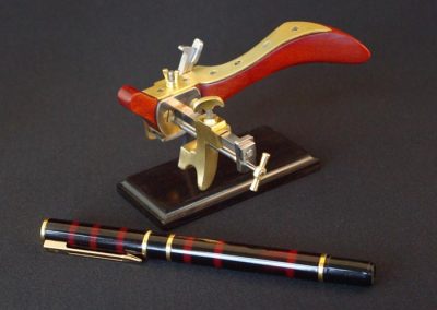 The miniature French coach maker’s plow plane sits beside a fountain pen for scale comparison.