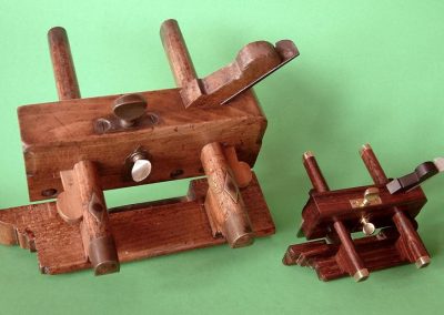 A full-size and miniature wedge-arm plow plane.