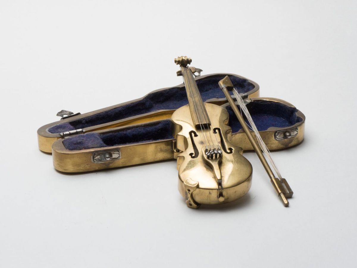 Miniature Violin Working even smaller, Abe crafted this miniature brass violin.