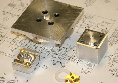 This photo shows the finished pump housing (lower left), and the brass impeller (lower right).