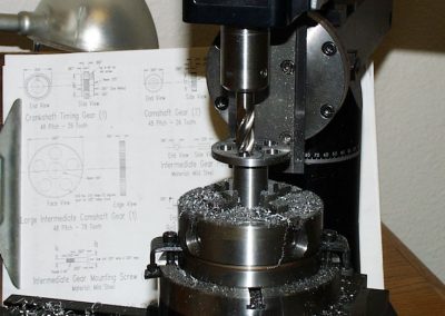 A Sherline mill was setup to open up the five lightening holes in the cam gear.