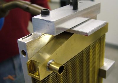 The top tank is placed in the fixture, and paste solder is applied to the joint.