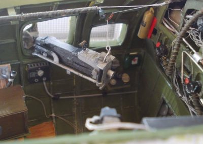 A scale .50 caliber machine gun hangs opposite the navigator’s seat.