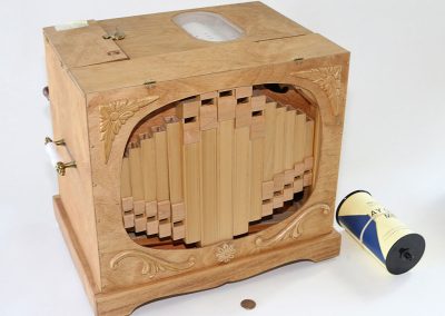 Birk carved each of the whistles and made the pump diaphragm for this hand-cranked organ.