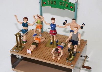 Seven hand-carved wooden figures go about various exercise routines when the hand crank is turned on this piece.