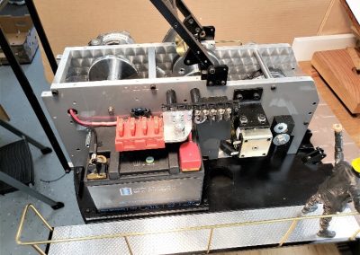 The battery, fuse holder, and terminal strip on the right side of the model crane.
