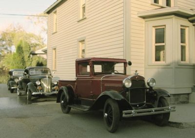 A sunset shot of two diecast cars outside of an Elgin Park home.