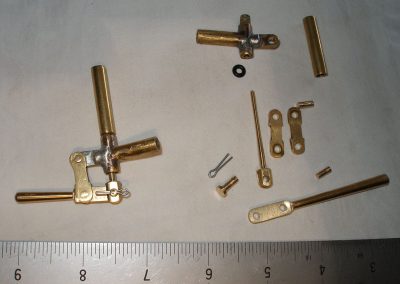 A ruler provides scale reference for these tiny metal parts.