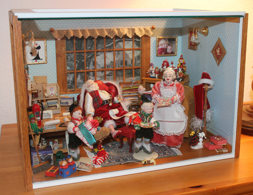 This 1/12 scale dollhouse room is aptly titled, “Santa’s Workshop.” In the miniature scene, Santa takes a snooze amid the construction of many toys.