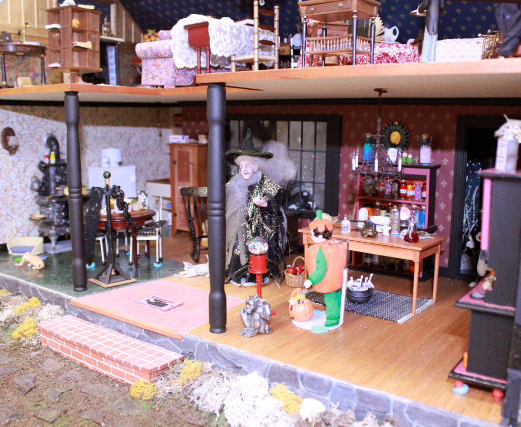This 1/12 scale 2-story dollhouse is called, “Witch’s House.” A few miniature trick-or-treaters can be seen daring to approach the wrinkled witch.