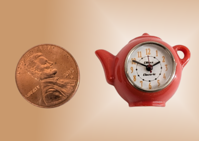 Teapot Kitchen Clock. Materials: Plastic body (ABS), nickel plated brass glass ring and back cover, glass. 1x1x.4