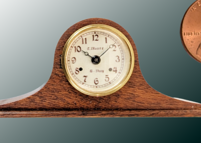 Tambour Clock. Materials: Lacquered black walnut case, silver plated brass dial and dial ring, brass bezel and feet, glass. 2x.9x.4